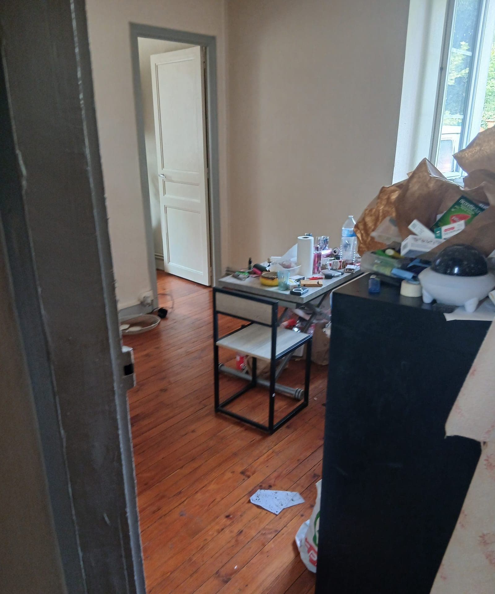 Pièce de vie encombrée, parquet à reprendre